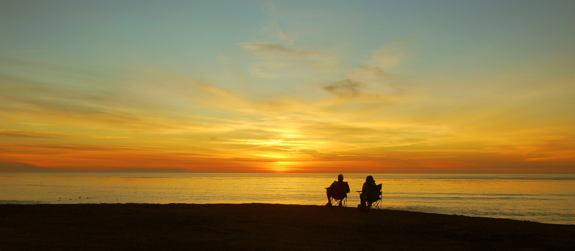 two people sat in silhouette watching the sunset - planning what retirement lifestyle you'd like to live